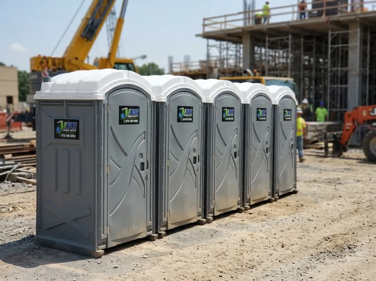 A row of blue porta potties lined up at a housing construction site.